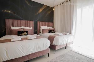Un dormitorio con dos camas y una pared negra. en YalaRent incredible Penthouses with all over sea view, en Eilat