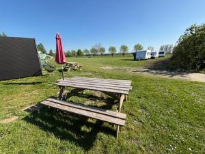 a picnic table and an umbrella in a field at trekkershut in Hulst