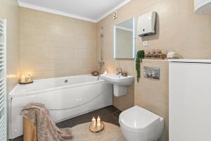 a bathroom with a tub and a toilet and a sink at GRAND CENTRAL apartment with 3 bedrooms in Porec! in Poreč +72 photos