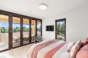 a bedroom with a bed and a tv and a balcony at GRAND CENTRAL apartment with 3 bedrooms in Porec! in Poreč
