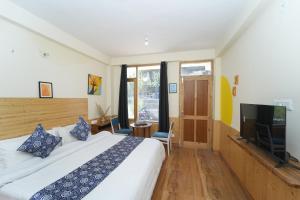 Un dormitorio con una cama y un televisor de pantalla plana. en Starway Homes, en Manali