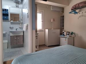 a bedroom with a bed and a sink and a bathroom at IL Ritratto casa vacanza in Scilla