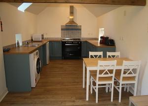 a kitchen with a table and a stove top oven at Honey Suckle Hideaway in Céaucé