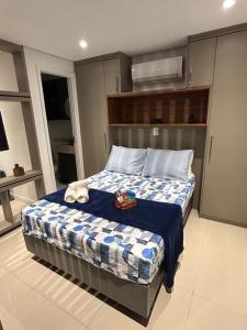 a bedroom with a bed with a blue and white comforter at Studio Novo Luxo - Centro in Mogi das Cruzes +76 photos