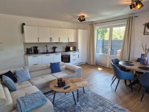 a living room with a couch and a table at Schöne FeWo in traumhafter Lage an der Nordsee in Dornum