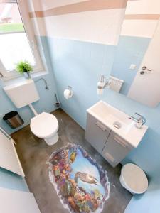 a bathroom with a toilet and a sink at Roschi's Gästehaus in Gudow +32 photos