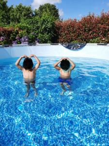 two children are standing in a swimming pool at Charmante maison de ville lumineuse avec piscine in Vannes