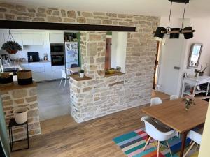 a kitchen and dining room with a brick wall at Charmante maison de ville lumineuse avec piscine in Vannes