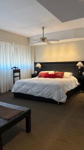 a bedroom with a large bed with red flowers on it at HOTEL COLL OFICIAL - BRAGADO Provincia de Bs As in Bragado