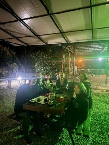 a group of people sitting at a picnic table at night at ŞAH apart in Kemer