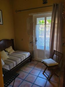 Cette chambre comprend un lit, une fenêtre et une chaise. dans l'établissement Appartement familial à Arles avec jardin et piscine, à Arles