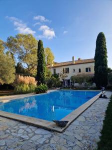 une piscine devant une maison avec des arbres dans l'établissement Appartement familial à Arles avec jardin et piscine, à Arles