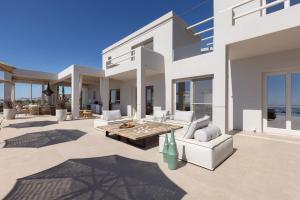 a living room with white furniture and large windows at Villa Dafni Tinos in Agios Fokas +41 photos