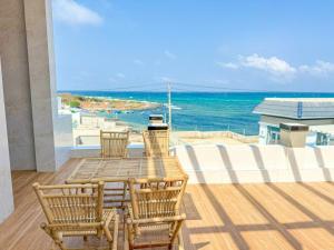un tavolo e sedie su un balcone con vista sull'oceano di HOMESTAY PHÚC LŨY a Cu Lao Thu