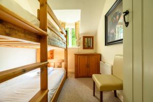 a bedroom with a bunk bed and a desk at Cosy Cotswold Lodge by Your Home Here - SALE for 3 PLUS NIGHTS - ideal for families, log-burner, spa, private parking, EVC included and heated swimming pools in Ashton Keynes