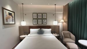 a bedroom with a large white bed and a chair at Dolphin Hotel in Visakhapatnam
