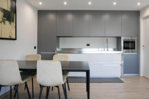 a kitchen with a black table and white cabinets at Casa del lago by Lago Maggiore Rentals in Oggebio