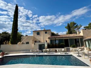 a swimming pool in front of a house at Le Mas de Garrigon - Boutique Hôtel & Spa in Roussillon