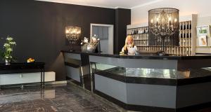 a woman sitting at a glass counter in a library at Victor's Residenz-Hotel Saarlouis in Saarlouis