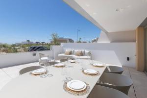 a white dining table and chairs on a balcony at EL Eden casa 71 in Málaga