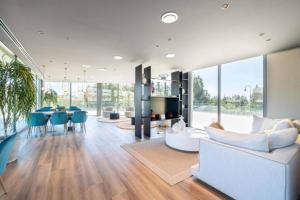 a living room with a white couch and blue chairs at EL Eden casa 71 in Málaga