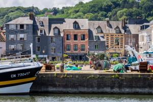 a boat is docked at a dock in a city at L'Absinthe Hôtel in Honfleur