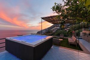 a hot tub with a view of the ocean at Villa Le Porpore in Furore