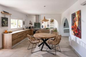 a kitchen with a wooden table and some chairs at Casa Ubedas in Almería