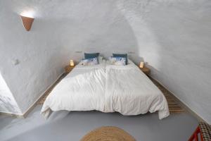 a bedroom with a white bed with blue pillows at Casa Ubedas in Almería