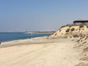 a sandy beach next to the ocean with a building at Casa Ubedas in Almería +45 photos
