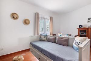a room with a bench with pillows and a window at Casa Amarela in Tavira