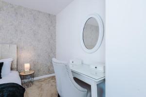 a bedroom with a bed and a desk with a mirror at Stylish 3 bed house sleeps 5 free parking in Dudley Hill +49 photos