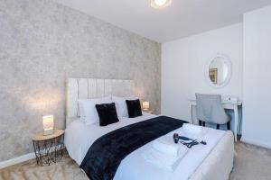 a bedroom with a large white bed and a desk at Stylish 3 bed house sleeps 5 free parking in Dudley Hill