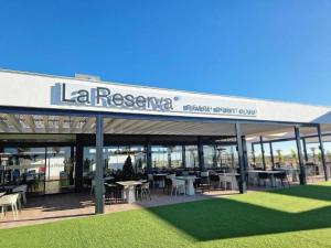 a restaurant with tables and chairs in a building at Villa Almendro Santa Rosalia Lake and Life Resort by PREMIUM SPAIN PROPERTIES in Torre-Pacheco