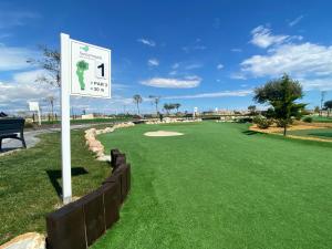 a golf course with a sign in front of a green at Villa Almendro Santa Rosalia Lake and Life Resort by PREMIUM SPAIN PROPERTIES in Torre-Pacheco