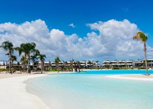 a view of a beach with palm trees and condos at Villa Almendro Santa Rosalia Lake and Life Resort by PREMIUM SPAIN PROPERTIES in Torre-Pacheco
