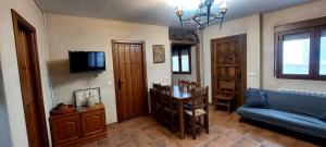 a living room with a blue couch and a tv at LAS CALLEJUELAS in Atienza