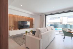 a living room with a white couch and a tv at Villa Almendro Santa Rosalia Lake and Life Resort by PREMIUM SPAIN PROPERTIES in Torre-Pacheco