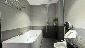a bathroom with a bath tub and a toilet at Apartment in Ho Tay in Hanoi