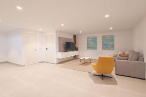 a living room with a couch and a chair at Villa Almendro Santa Rosalia Lake and Life Resort by PREMIUM SPAIN PROPERTIES in Torre-Pacheco