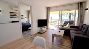a living room with a couch and a tv and a bed at Apartamento con Vistas al Mar in Empuriabrava