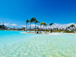 a beach with palm trees in the water at Villa Almendro Santa Rosalia Lake and Life Resort by PREMIUM SPAIN PROPERTIES in Torre-Pacheco