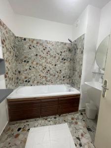 a bathroom with a bath tub and a sink at Appartement T3 in Abidjan