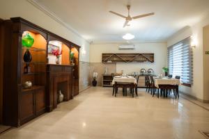 a dining room and kitchen with tables and a ceiling fan at Ahuja Residency Cyber City I in Gurgaon