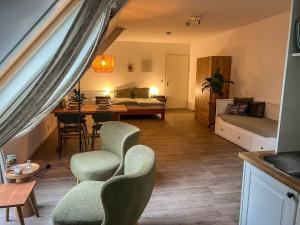 a living room with a bed and a table and chairs at Studio lodge de Bosuil bij Bolmeer Lodges in Zevenhuizen