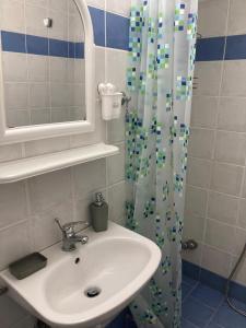 a bathroom with a sink and a shower curtain at Relax and enjoy in Raches
