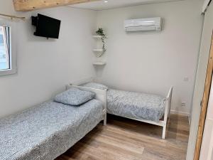 a small room with two beds and a tv at Chambres au calme, free parking in Cagnes-sur-Mer
