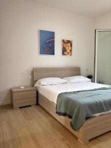 a bedroom with a large bed and two pictures on the wall at VINCI - Narramondo Villas in Tortoreto Lido
