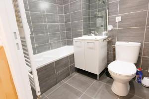 a bathroom with a toilet and a sink and a tub at Duplex Cosy Glam au Centre-Ville secteur piéton * WiFi * Calme in Troyes