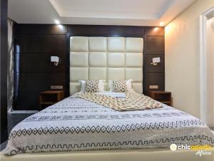 une chambre avec un grand lit avec une grande tête de lit dans l'établissement Studio chic avec parking près de l'aéroport, à Douala 10 autres photos